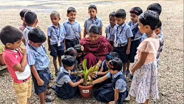 teacher and students planting plant